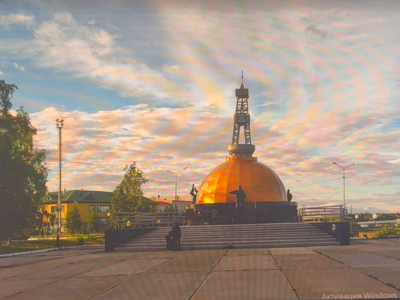 Памятник первооткрывателям самотлорской нефти. Его возвели в 1972 году недалеко от первой разведочной скважины Самотлорского месторождения. Сначала это была небольшая металлическая вышка с надписью «Первая скважина Самотлора. 1965 год». Через пять лет вышку заменили капитальной стелой, символизирующей буровую установку.  В 2015 году памятной стеле придали новый облик. Сооружение высотой 18 метров состоит из основания в виде капли нефти, разделённой пилонами на четыре секции. В каждом из них установлены гранитные таблички с именами людей, прославленных достижениями в направлениях: бурение, добыча, строительство и транспорт. Архитектурный комплекс дополняют три 22-х метровые мемориальные плиты. Как символ мужества и несгибаемой воли на них высечены имена тех, кто в разное время ковал славу Самотлора.  